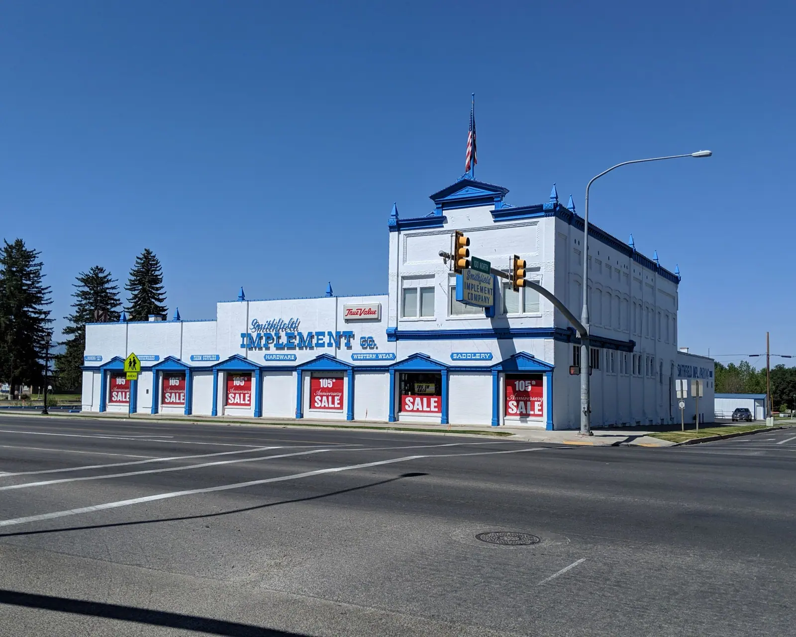 The storefront with sale signs in the windows under a clear sky